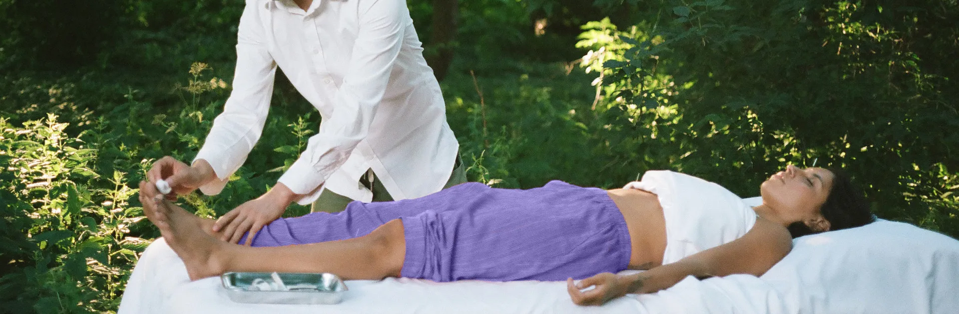 Séance d’acupuncture : pose d’une aiguille au pied, la personne allongée et détendue