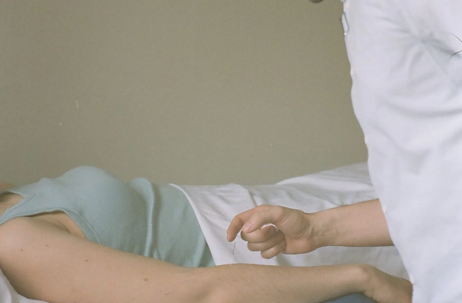 L’avant-bras d’une personne allongée, posé sur un coussin, la main du clinicien juste au-dessus