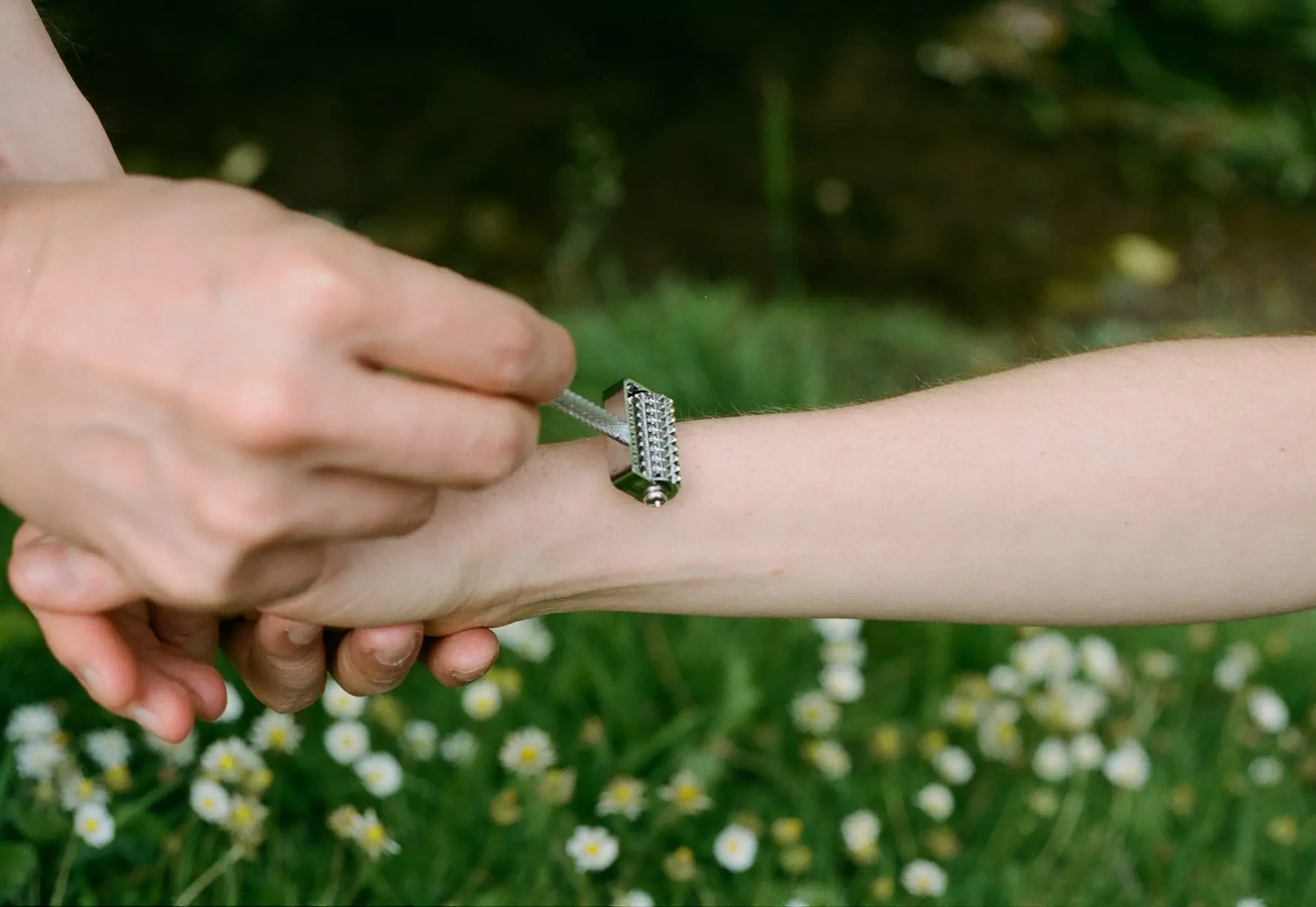 Un petit rouleau à pointes passé sur l’avant-bras, au-dessus d’un pré de marguerites