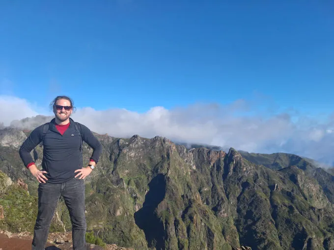 Josh Whelan en montagne, au-dessus d’une mer de nuages, face à des crêtes escarpées