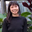 Portrait de Jessica Chan, souriante, devant un feuillage